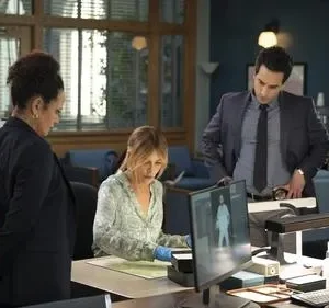 Seis profissionais diversos, incluindo homens e mulheres, trabalhando juntos em um escritório. Eles examinam telas e documentos com foco sério.