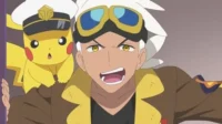 Anime: Um homem de cabelo branco e óculos de aviador com um Pikachu de chapéu de capitão. Ambos parecem chocados/surpresos em ação.