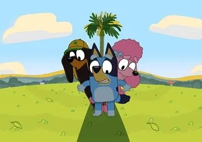 Três personagens caninos animados (azul, marrom, rosa) espiam sobre uma colina verde com um coqueiro ao fundo.