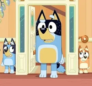 Um cachorro adulto azul e preto surpreso na porta, com dois filhotes, um curioso e outro tímido, espiando de trás.