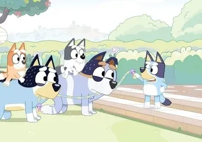 Família de cães estilizados brinca de trenzinho em jardim ensolarado. Dois cães grandes carregam dois pequenos, enquanto um terceiro lidera com guia.