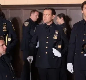 Grupo de policiais em uniformes azuis-escuros formais, com luvas brancas e chapéus na mão, em evento cerimonial.