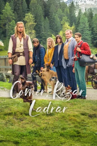 Grupo de seis pessoas, incluindo um homem de cabelo comprido e vestuário rústico, e três cães, em um cenário montanhoso e florestal.