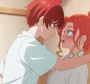 Homem ruivo inclina-se sobre mulher de cabelo laranja, que cora e expressa surpresa. Seus rostos estão próximos em um abraço terno.