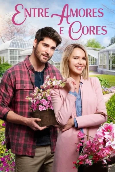 Um casal sorridente segura flores num exuberante jardim com estufas. Um clima romântico e primaveril domina a cena.