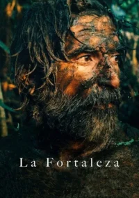 Close-up de homem sujo de lama,com barba e cabelo molhados,em floresta escura. Expressão intensa de sobrevivência.