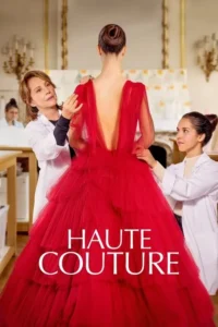 Num ateliê,uma costureira mais velha ajusta um vestido vermelho esvoaçante em modelo. Uma jovem assistente observa atentamente. Elegância e foco.