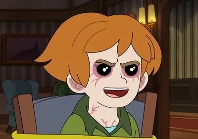 Criança animada ruiva com olhos avermelhados e veias visíveis sorri maliciosamente num quarto escuro e antigo.