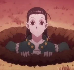 Pessoa de cabelo escuro e roupa verde emerge de um buraco na terra. Fundo de campo árido avermelhado. Expressão neutra.