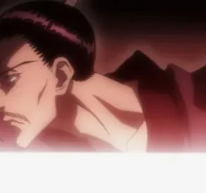 Homem de perfil com cabelo escuro e bigode, em vestes vermelhas, olha intensamente para a esquerda. Fundo escuro com luz branca vibrante na base.