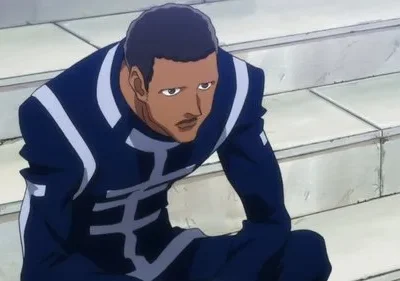 Homem de pele escura com uniforme azul e detalhes brancos, sentado em degraus claros. Parece sério e pensativo.