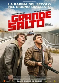 Dois homens, um com espingarda e outro com sangue na camisa, olham para cima preocupados numa ponte. Carro da polícia ao fundo.