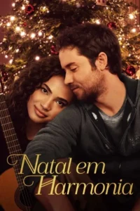 Casal em abraço aconchegante. Mulher sorri com violão,encostada em homem barbudo. Fundo de árvore de Natal com luzes quentes. Clima romântico.