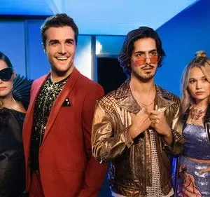 Quatro personagens com roupas estilosas de festa em um cenário noturno azulado. Um homem sorri, os outros têm expressões sérias.