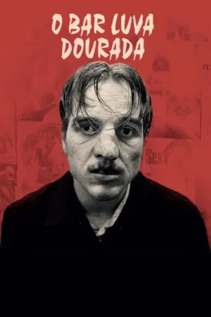 Close de um homem pálido e com bigode, cabelo desgrenhado e olhar intenso. Fundo vermelho desbotado com figuras indistintas. Clima tenso.