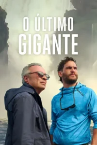 Dois homens,um de cabelo grisalho e óculos e outro jovem barbudo,observam um cenário nebuloso de rochas e mar. Clima de exploração.