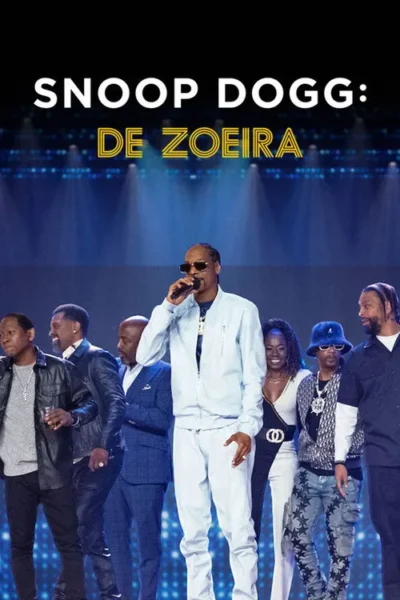 Homem de óculos escuros e agasalho claro canta no palco azul. Vários homens e uma mulher de estilos diferentes o cercam animadamente.