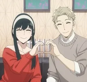 Mulher de cabelo escuro em vermelho e homem loiro em cinza sorriem, formando um coração. Cena de anime em sala, clima feliz.