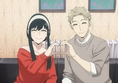 Mulher de cabelo escuro em vermelho e homem loiro em cinza sorriem, formando um coração. Cena de anime em sala, clima feliz.