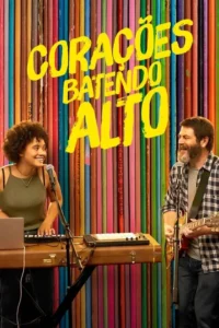 Um duo sorridente de músicos. Mulher toca teclado e homem barbudo toca guitarra,contra um fundo vibrante de discos de vinil.