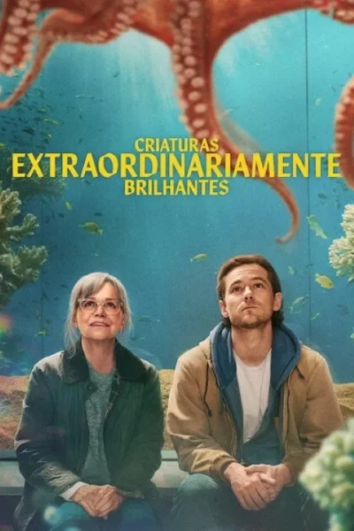 Uma mulher e um homem sentados, olhando para cima, com um grande polvo e peixes num aquário ao fundo. Atmosfera curiosa.