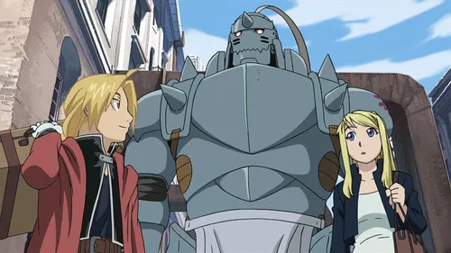 Fullmetal Alchemist:Brotherhood – T01E16:Os Passos de Um Amigo 1 Fullmetal Alchemist:Edward sorrindo com mala,Alphonse (armadura) e Winry surpresa,em rua urbana. Clima de aventura.