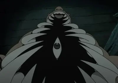 De Fullmetal Alchemist, um monstro musculoso e sorridente. Um olho vertical se destaca de uma massa peitoral escura com pontas afiadas. Fundo escuro.
