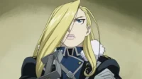 Fullmetal Alchemist:Brotherhood – T01E34:A Rainha do Gelo 9 Olivier Armstrong de Fullmetal Alchemist:Mulher loira séria em uniforme militar azul e preto com gola de pele. Olhar determinado.