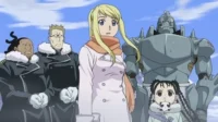 Fullmetal Alchemist:Brotherhood – T01E41:Inferno 3 Alt Text:Fullmetal Alchemist:Winry,Alphonse,May e outros personagens em casacos de inverno,parecendo alertas nas montanhas nevadas.