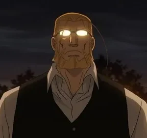 Em Fullmetal Alchemist, um homem barbudo e imponente com óculos de olhos brilhantes. Chamas ao fundo intensificam o cenário noturno dramático.