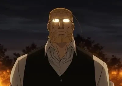 Em Fullmetal Alchemist, um homem barbudo e imponente com óculos de olhos brilhantes. Chamas ao fundo intensificam o cenário noturno dramático.