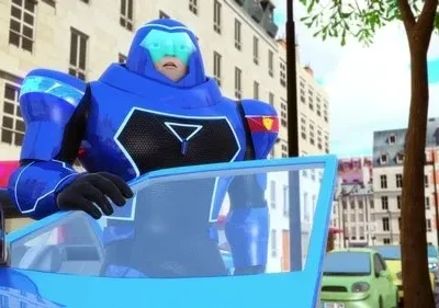 Homem em armadura azul futurista e surpreso, dirigindo carro azul com luzes vermelhas. Rua de cidade com prédios claros.