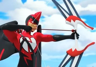 Personagem animado com traje de herói vermelho e preto, asas de pássaro, máscara e um coração no peito, mirando um arco e flecha. Céu claro.