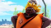 Monstro chef roxo com cabelo espetado amarelo e rosto furioso, sorrindo maldosamente. Visto ao ar livre com céu azul.