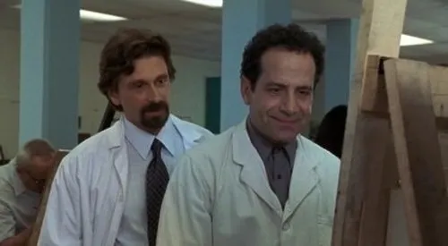 Monk:Um Detetive Diferente – T01E05:Sr. Monk Vai Para o Sanatório 1 Adrian Monk e Dr. Caldicott (Michael Douglas) em jalecos brancos sorriem em um cenário clínico de Monk.