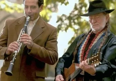 Monk (Tony Shalhoub) no clarinete e Willie Nelson no violão, tocando um dueto musical em cena da série Monk.