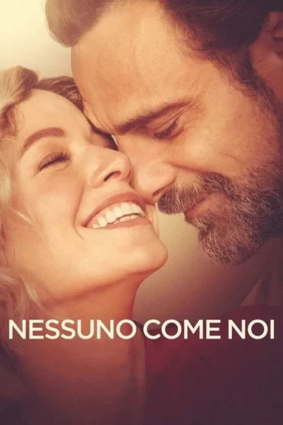 Close-up de casal: mulher loira sorrindo com olhos fechados, homem barbudo com rosto perto. Ambiente caloroso e romântico.