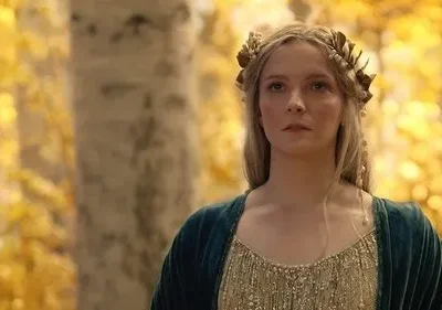 Galadriel de Os Anéis de Poder, loira com coroa de folhas douradas, olha séria em floresta outonal. Clima épico.