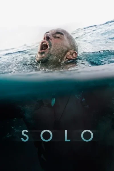 Homem barbudo com boca aberta e olhos fechados, lutando na água. Metade do rosto acima da superfície, corpo submerso no azul escuro.
