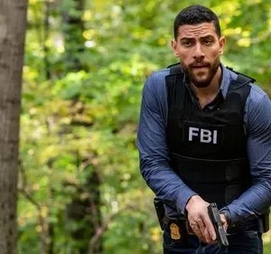 Agente do FBI, com colete tático e arma, alerta em uma floresta. Pôster da série FBI com clima de investigação e ação intensa.