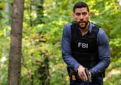 Agente do FBI, com colete tático e arma, alerta em uma floresta. Pôster da série FBI com clima de investigação e ação intensa.