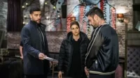 Pôster de Detetives Noturnos:Três figuras tensas em um bar escuro com arte urbana. Homem de casaco entrega papéis,mulher observa.