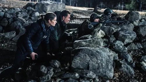 Agentes e atiradores em [Nome do Filme/Série] se abrigam atrás de uma parede de pedras,prontos para ação. Cena noturna tensa.