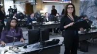The Hot Zone:Julianna Margulies e uma mulher em centro de operações movimentado. Computadores e mapa no fundo sugerem investigação/crise.