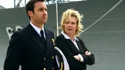 Hawaii Five-0: Steve McGarrett, em uniforme naval, e uma mulher loira séria, com um navio militar ao fundo.
