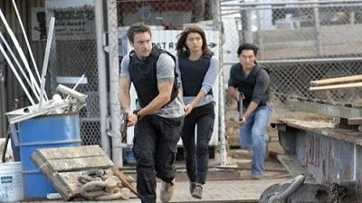 Havaí Cinco-0 – T01E02:Ohana (Família) 1 Aqui está uma opção de texto alternativo conciso:Em Hawaii Five-0,três agentes (dois homens,uma mulher) correm com coletes em área industrial,armas em punho. Ação tensa.