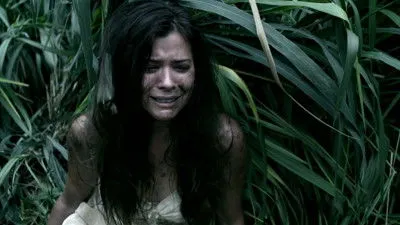 Pôster de Lost: Kate Austen, suja e em prantos, emerge de folhagem densa. O clima é de desespero e sobrevivência.